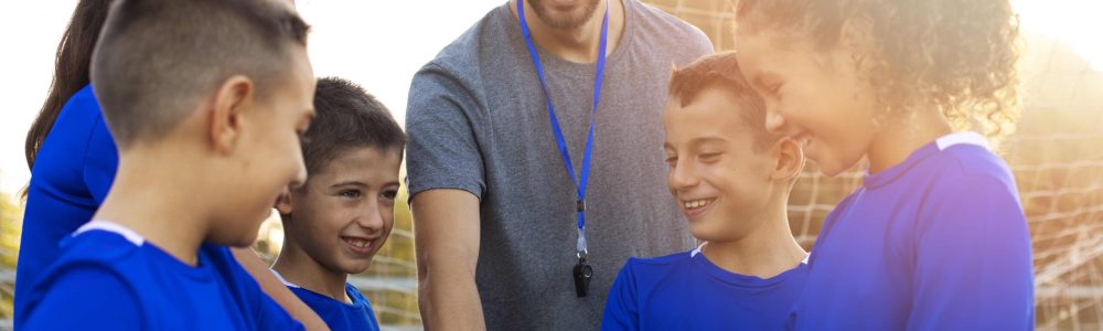 football-trainer-helping-kids-medium-shot (2)